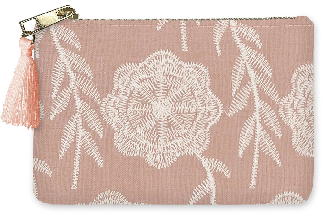 Pink pouch with white embroidered floral pattern and tassel on a pink background