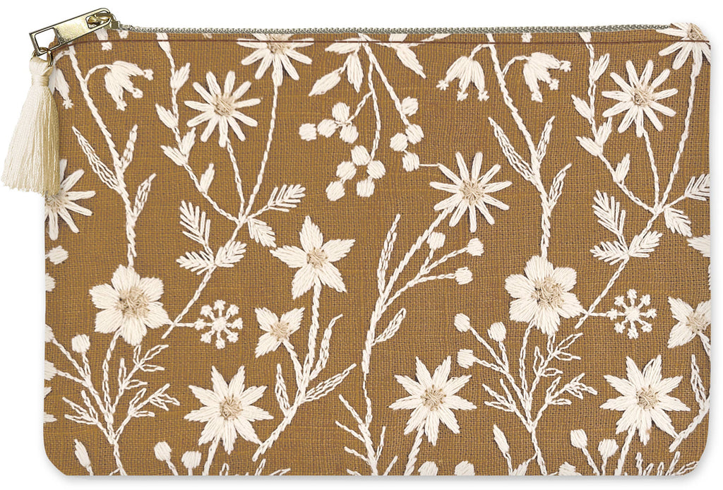 cream colored floral embroidery pouch on a brown background with a zipper and cream colored tassel